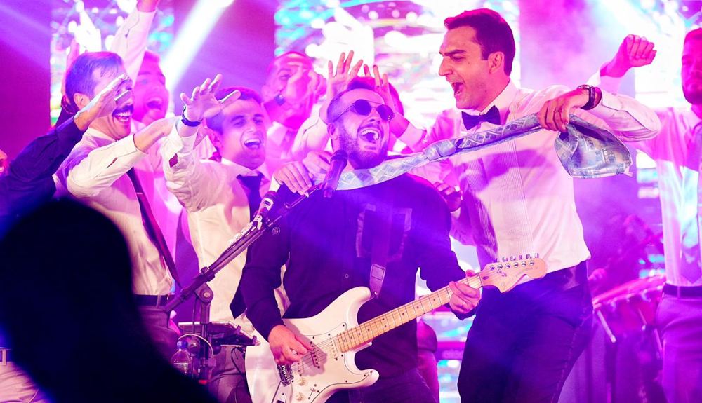 Padrinhos cantando com a banda no palco de um casamento