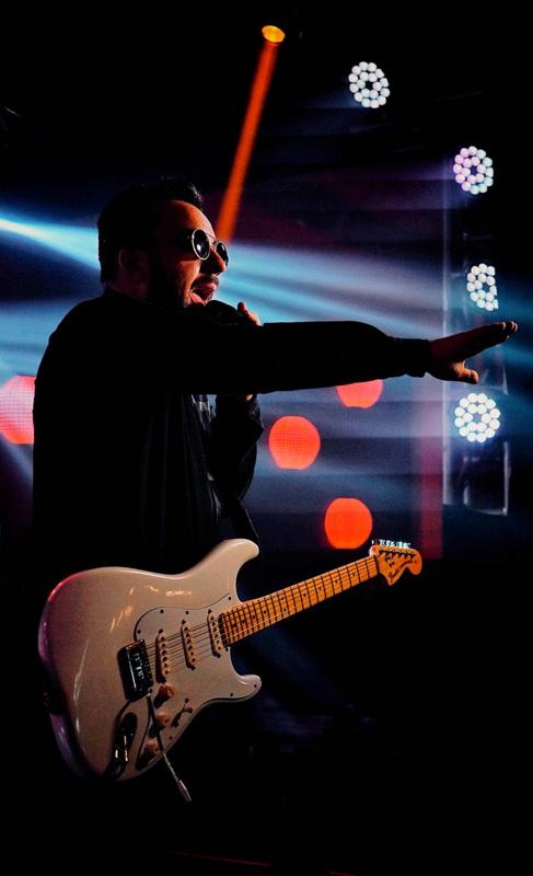 Léo em silhueta com guitarra branca